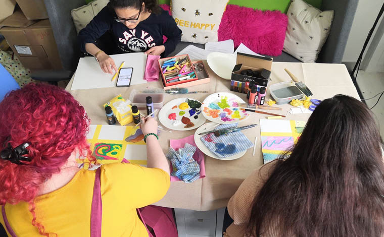 people around a table full of craft supplies