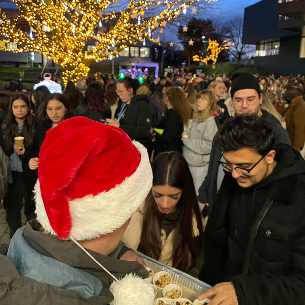 A person in a santa hat giving out free food