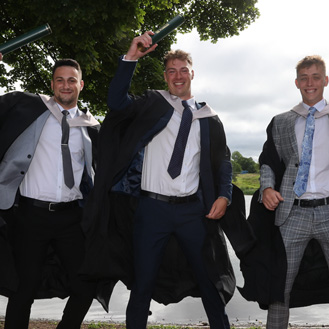 students with scrolls on graduation day