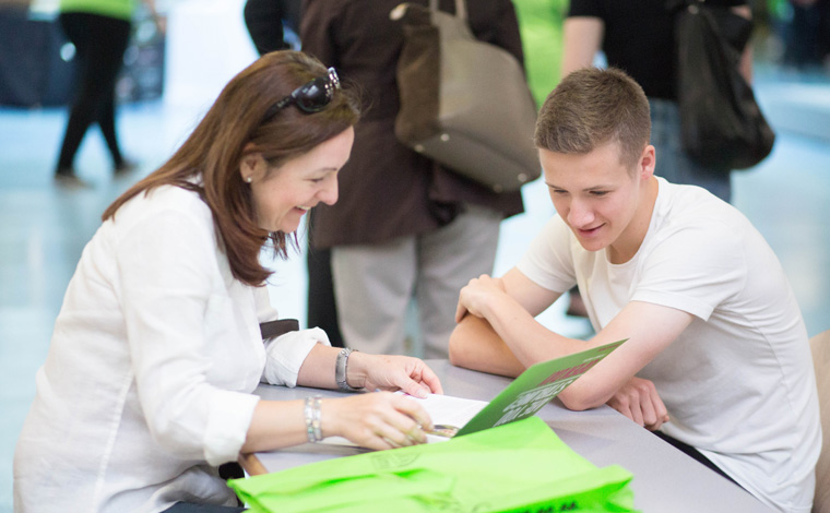 Two people sat at a table looking at a prospectus