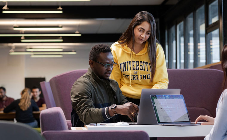 Two students looking at a laptop screen