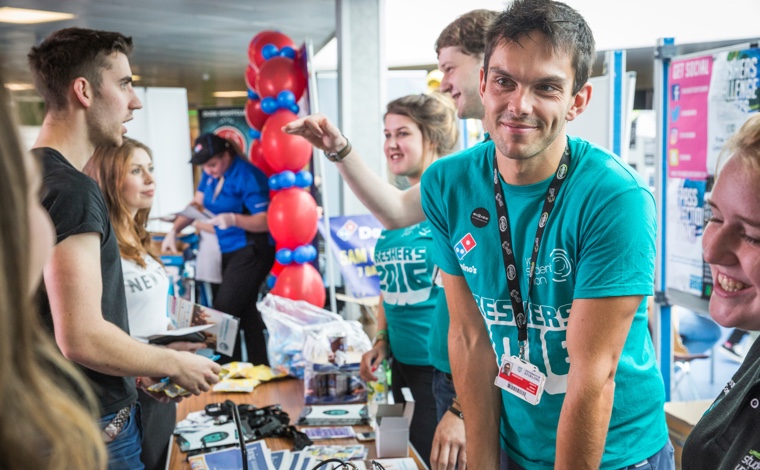 A student union representative at a stall during freshers week