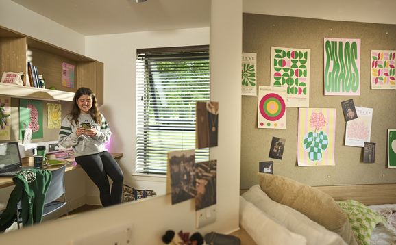 Student standing in a bedroom in student accommodation