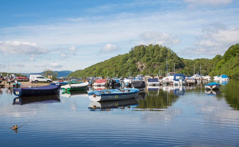 A selection of colourful boats moored on the banks of Balmaha