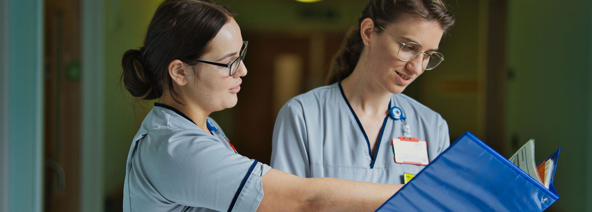 Two student nurses reading a case file