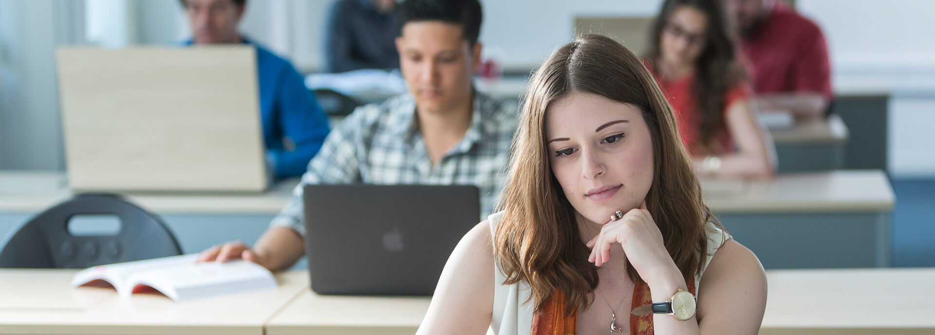 Male and female student in classroom using laptop computers