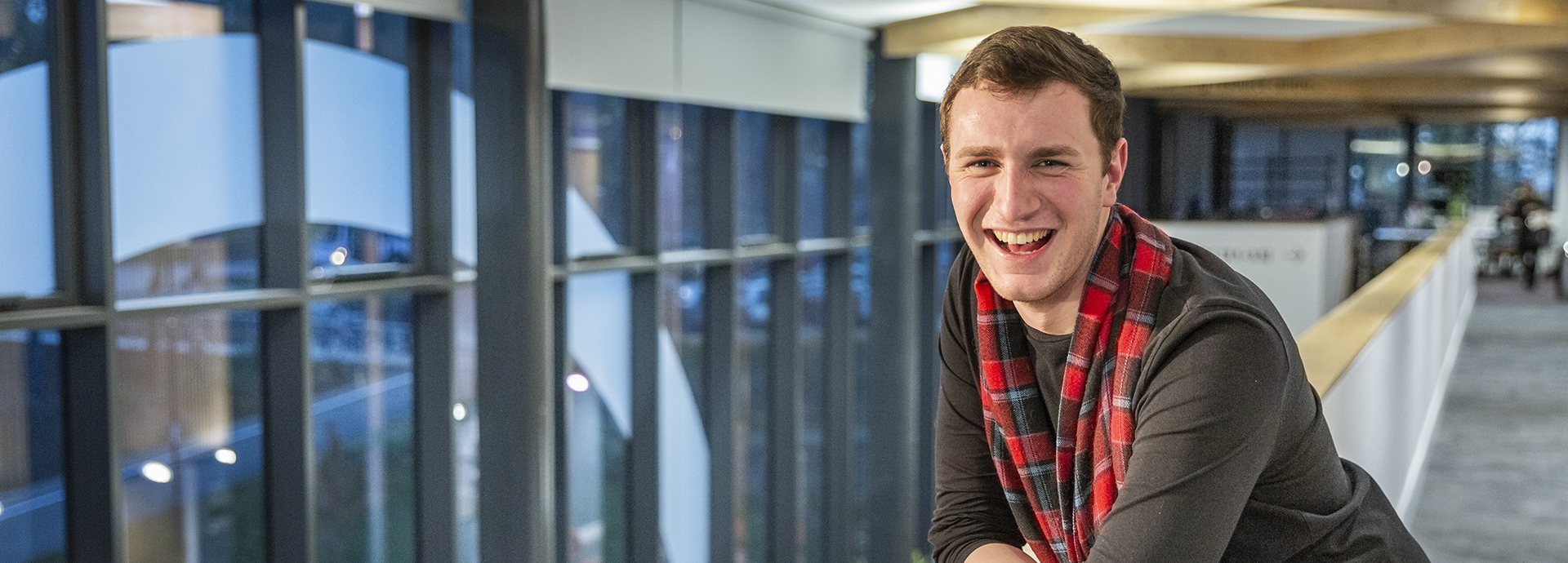 Student standing in the INTO building