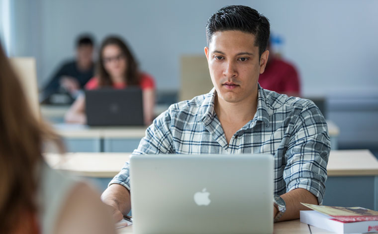 A student typing on a laptop computer