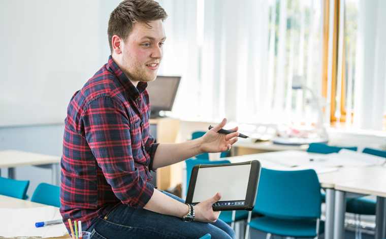 student sitting on table with tablet-760x470