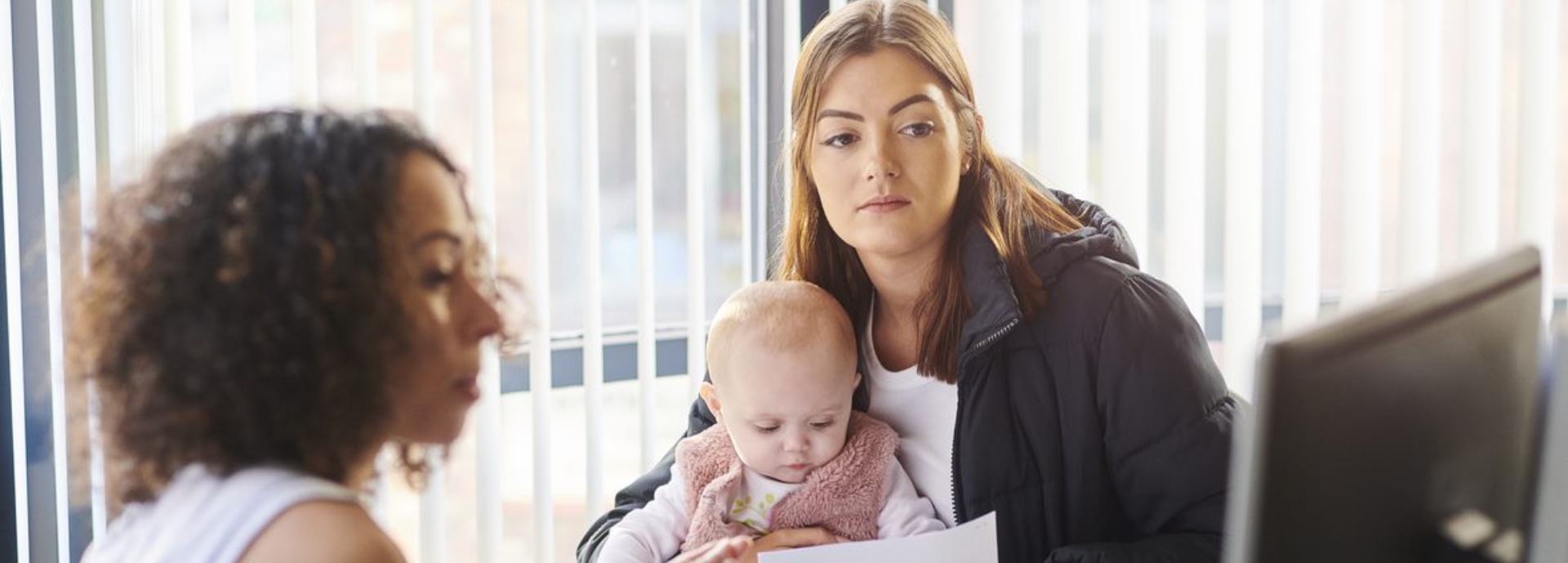 women and baby at desk