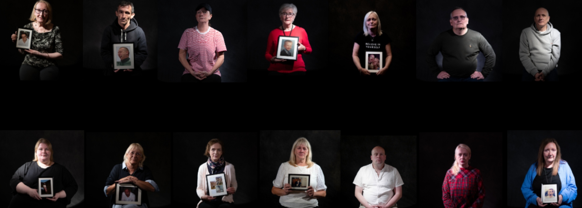 People sitting holding photographs