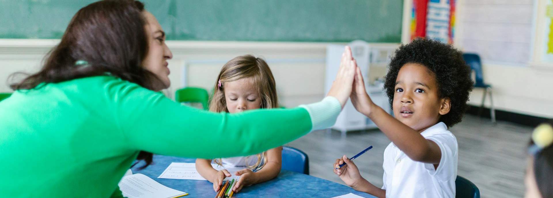 teacher high fiving student in class