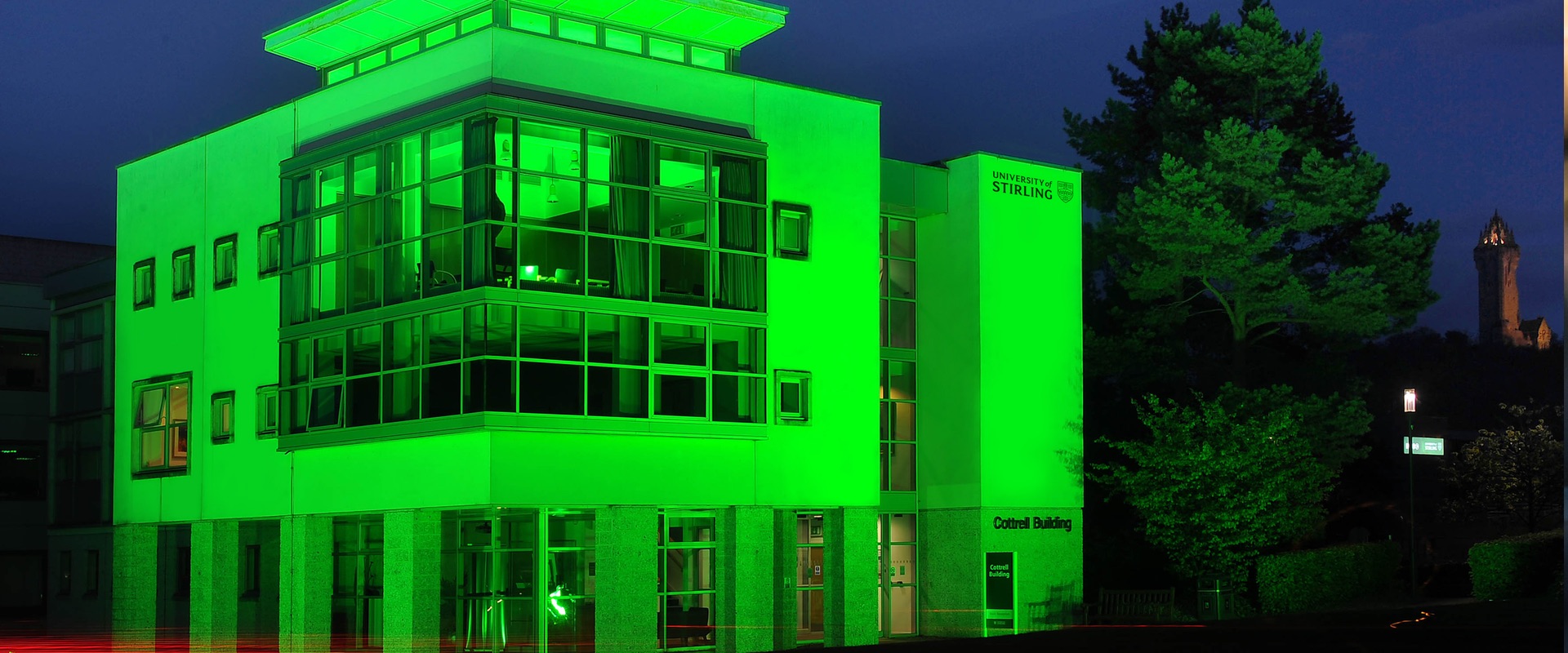 Cottrell building lit up with green light