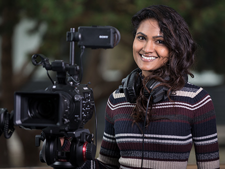 Postgraduate student with filming camera and headphones