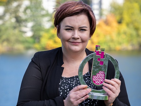 Head and shoulders shot of woman holding a trophy