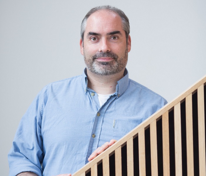 Head and shoulders shot of man with beard in blue shirt