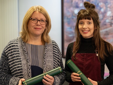 two women with university scrolls