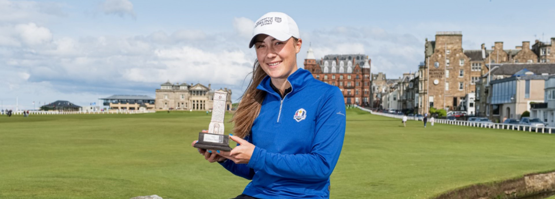 Hazel MacGarvie sitting on the Swilken Bridge with the St Rule Trophy at the Old Course, St Andrews