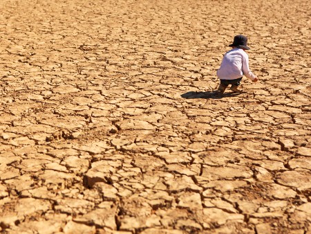 Child Playing on Dry Parched Desert Land stock photo