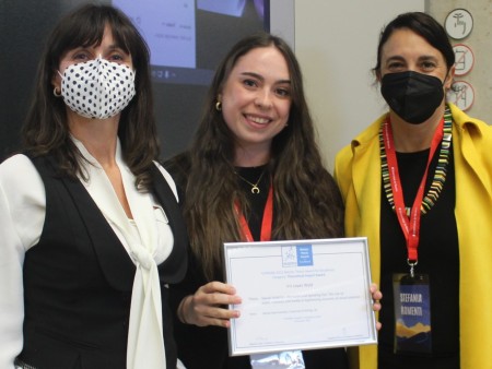 PR award winner Iris holds her framed certificate