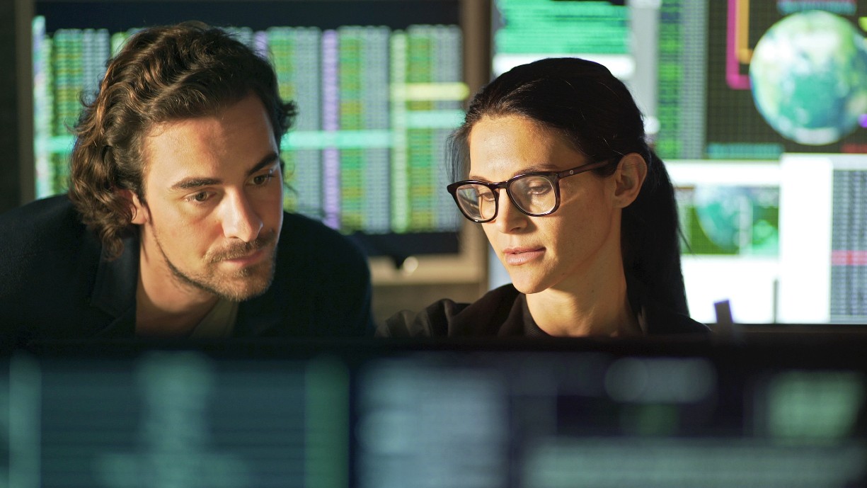 Stock shot of man and woman looking at data