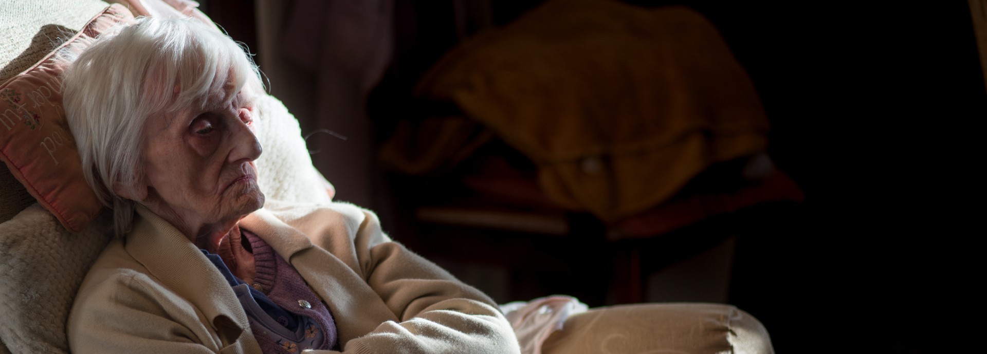 Elderly lady sitting in the dark