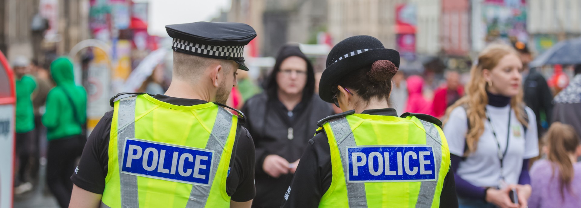 Two police officers from behind in a crowd