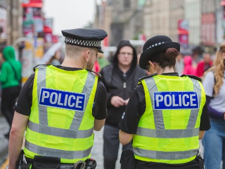 Two police officers from behind in a crowd