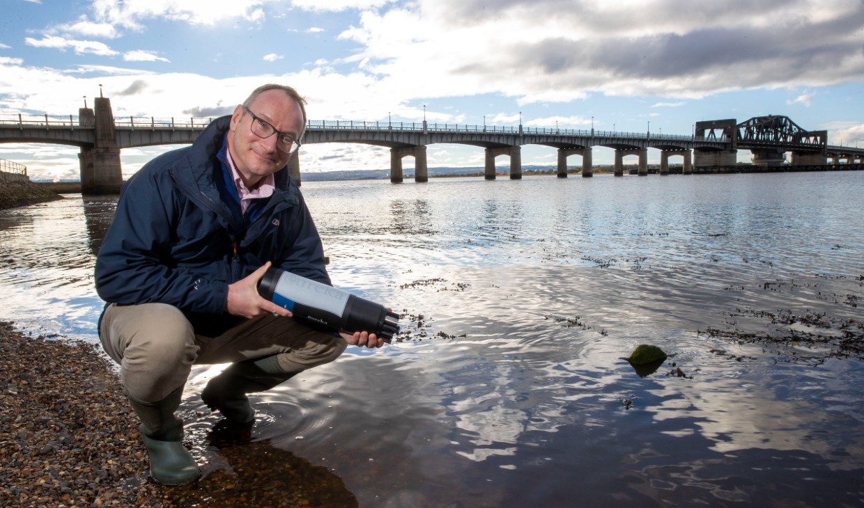 Prof Andrew Tyler holding sensor by Kincardine bridge