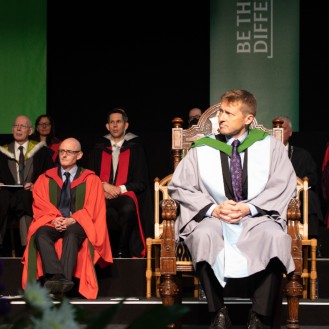 Honorary graduate Mike Robinson on stage at graduation