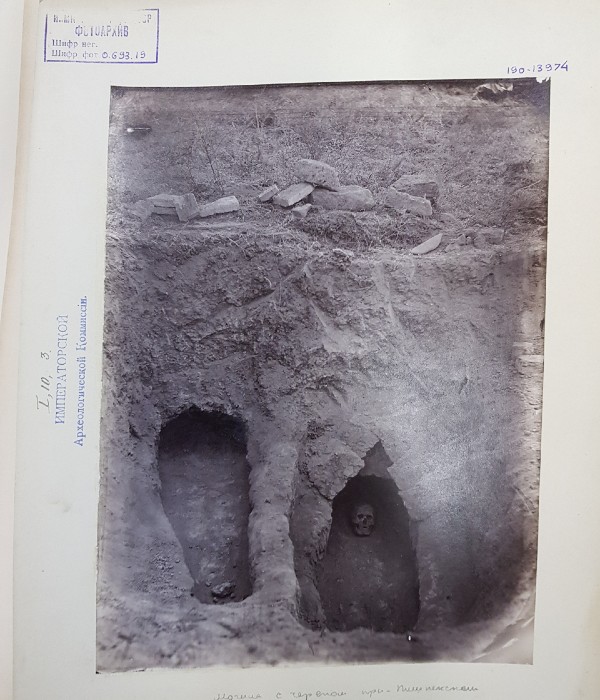 Black and white photograph shows a medieval skeleton in a grave