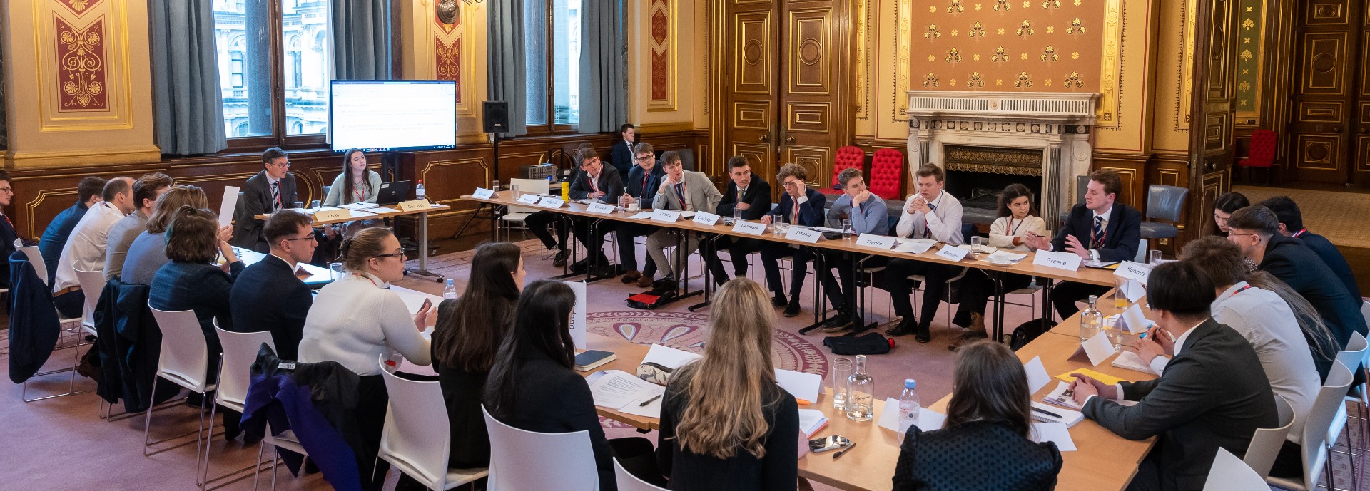 Student delegates sitting round the table at the Model NATO event at the Foreign Office