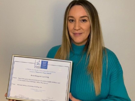 Anne Cumming photographed with her award certificate.