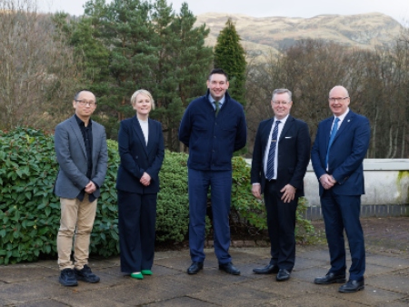 Group of people posing outdoors in front of trees