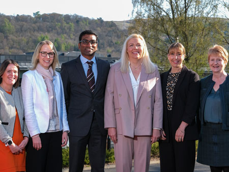 Six healthcare experts and academics stood next to each other outside