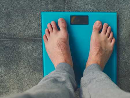 A man's feet standing on scales