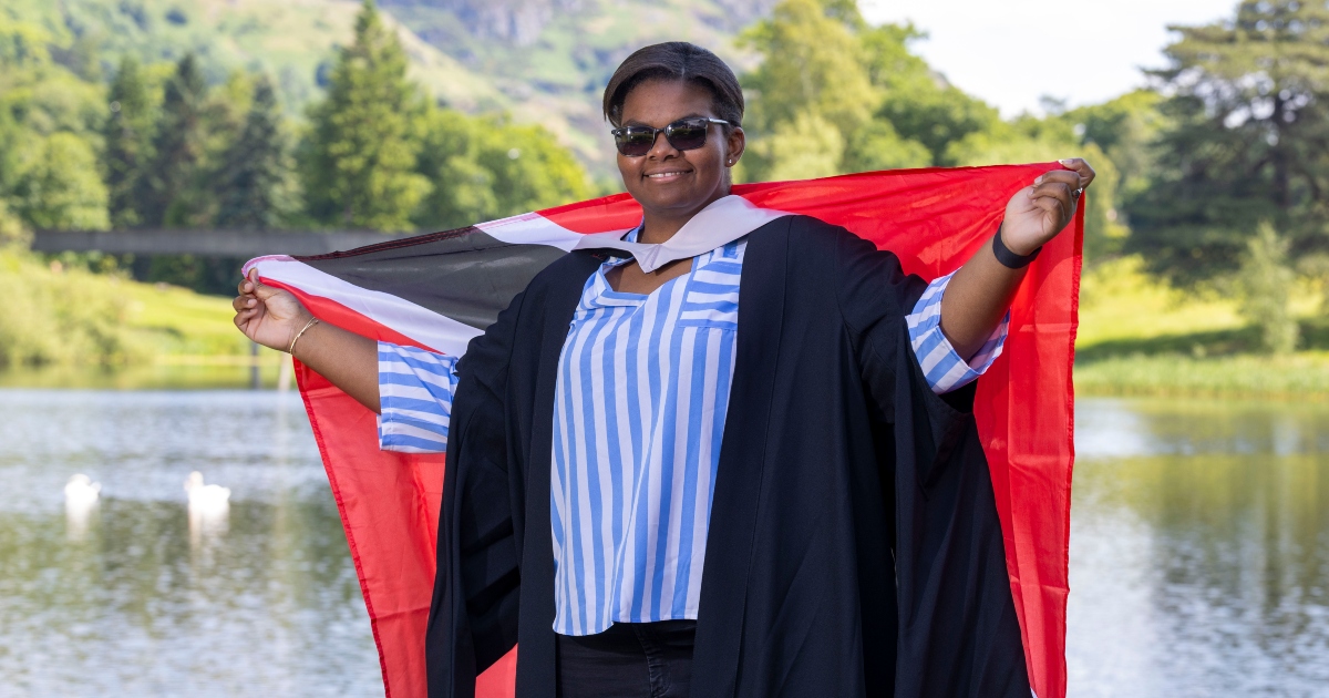 Gabriella Wood poses on University of Stirling campus with Trinidad and Tobago flag.