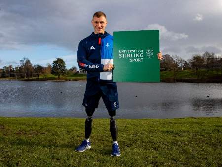 man with artificial legs holding sign