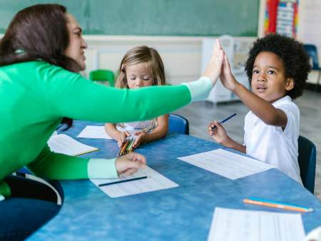 teacher high fiving student in class