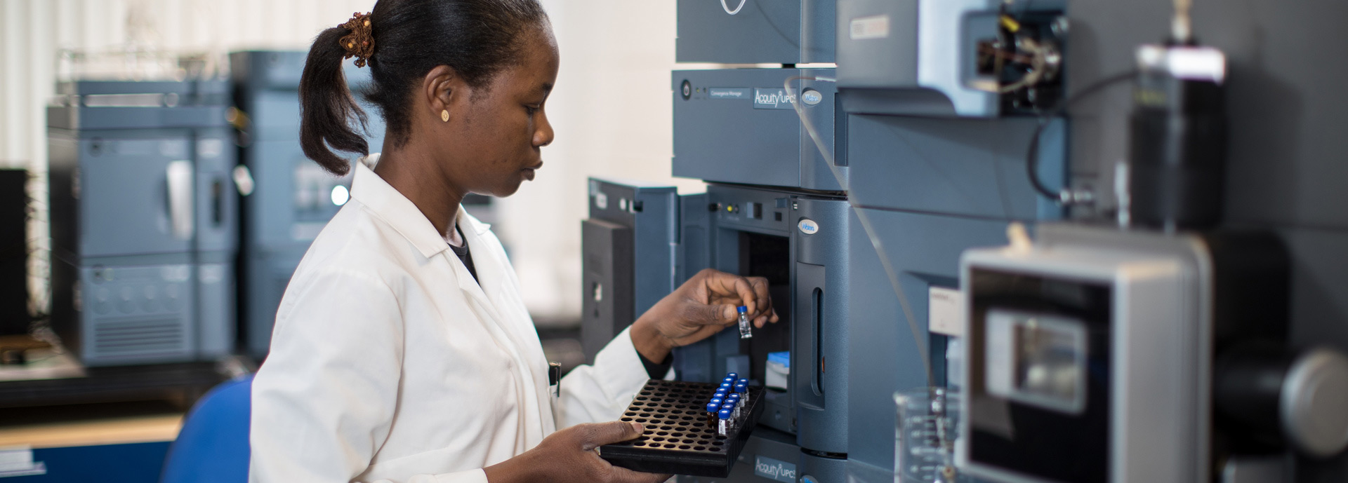 Woman in white coat using aquaculture laboratory equipment