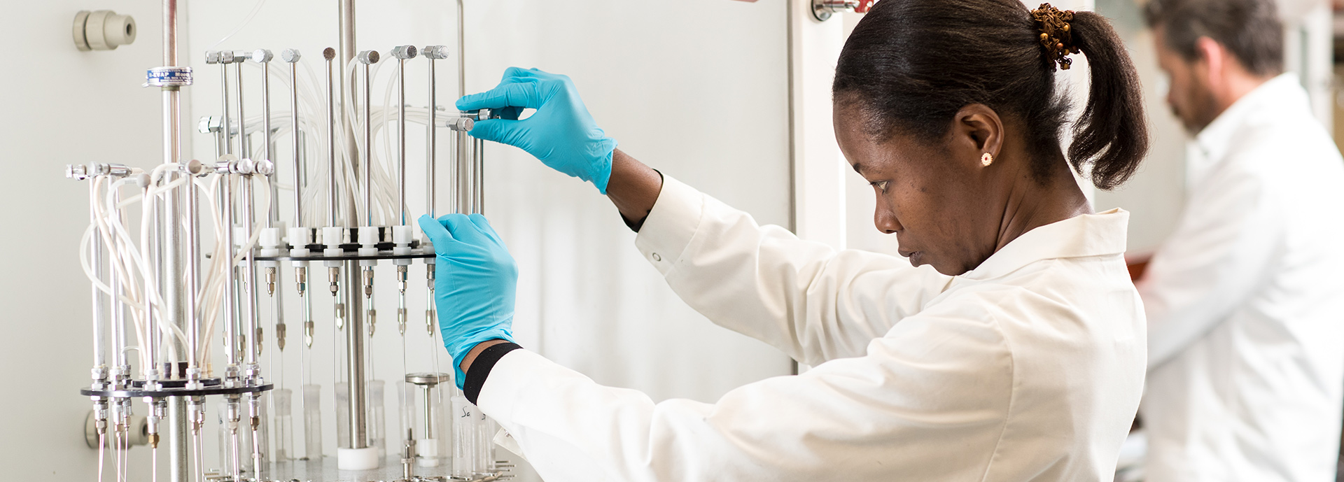 Woman in white coat using aquaculture equipment