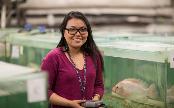 Woman standing next to large aquarium