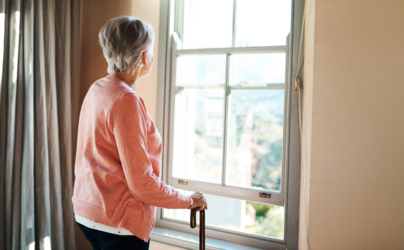 older person looking out window