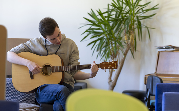 Student playing a guitar