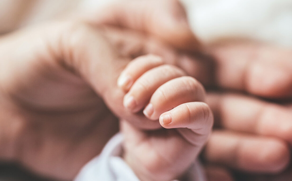 baby hand holding an adult hand