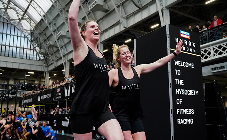 Two runners crossing Hyrox finish line