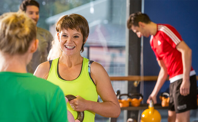 Woman talking to a member of staff at the gym